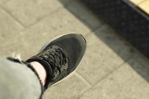 cruce negro en la pierna de una mujer. zapatos de mujer en verano. foto