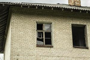 una casa abandonada con ventanas rotas. edificio antiguo en la ciudad. foto