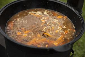 Soup in a pot. Food outside. Cooking soup on an open fire. photo