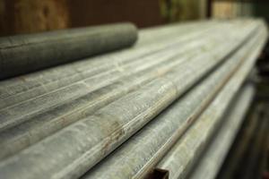 Steel pipes lie in a pile. Material in stock. Industry in detail. photo