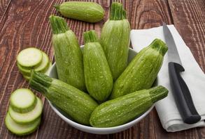 Raw fresh zucchini isolated on wooden background. photo