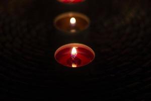 Round candles burn in the dark. Flame from burning wax. photo