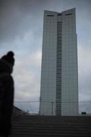 Tall building in city. Silhouette is blurry. House with offices. photo