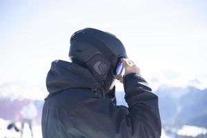 Snowboarder straightens his helmet photo