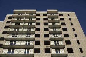 edificio en construcción en la ciudad. las ventanas no están completamente insertadas en la pared de la casa. foto