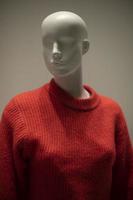 Mannequin in a red sweater. Shop window. Wool-bound clothing. photo