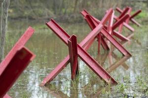 Anti-tank crosses are in the water. Barrage from military equipment. photo