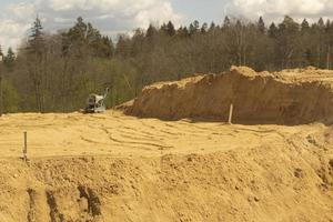 Sand platform. Laying sand in the base. A lot of building material. photo