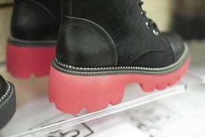 Black boots with red soles. Fighters on a high platform. Details of the clothing store. Sale of shoes. photo
