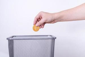 Etherium gold coin close-up on a gray background is thrown in the trash. photo