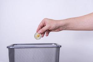 Etherium gold coin close-up on a gray background is thrown in the trash. photo