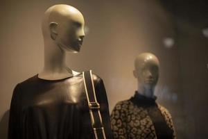 Two women's mannequins in a clothing store. A mannequin in a leather jacket and with a bag on his shoulder. photo