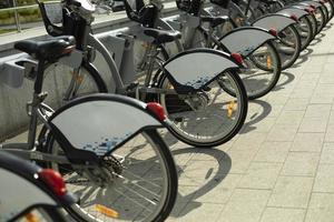 Bicycles for rent stand in a row on the street. photo