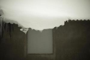 Snow on roof. Snowdrift hangs from edge of roof. After snowstorm. photo