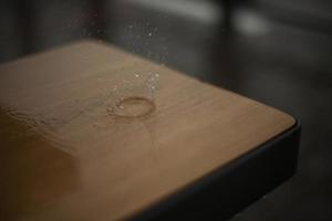 Raindrops break on the surface of the bench. Rain outside in detail. photo