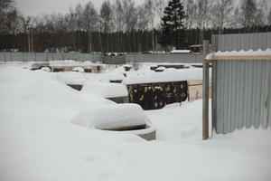 Construction site fence littered with snow. Construction site fencing in Russia. Tin fencing of an abandoned area. photo