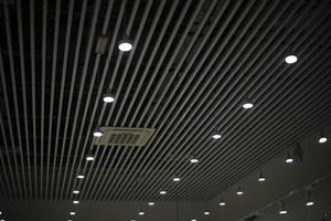 Ceiling inside building. Lamps in row. Lighting equipment for large area. photo