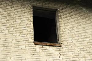 An abandoned house with broken windows. Old building in the city. photo