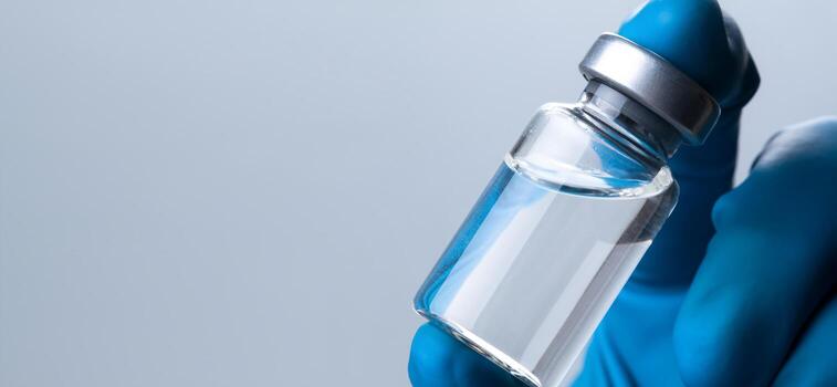 mano sosteniendo viola con vacuna contra el virus de la corona. foto