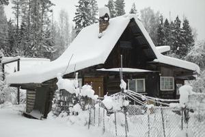 casa de campo en invierno. el techo está cubierto de nieve. campo. foto