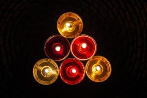 The candles are laid out in a triangle. Candles burn in the dark. Red and yellow wax. photo