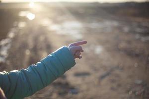 The child points with a finger. Hand in the sunlight. photo