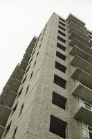 ventanas de la casa en construcción. construcción de un edificio en la ciudad. construcción de un edificio de apartamentos. el edificio no está revestido. foto