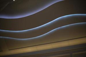 Ceiling in the mall. Light in the big interior. Lamps in the form of a wave on the ceiling. photo