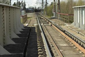 el ferrocarril es de un solo carril. la línea converge en la distancia. el camino para el movimiento del tren. rieles y durmientes. foto