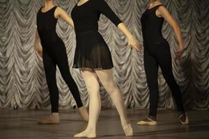 The girls rehearse the dance. Ballerinas in class. A girl in a black dress. photo