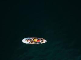 Mother with two daughters stand up on a paddle board photo