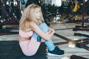 Girl sits on the floor in the gym photo