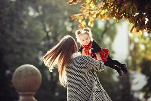 Mother and little daughter playing in a park photo