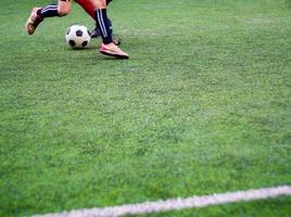 The footballers are competingon on the artificial grass turf of school photo