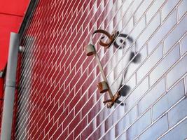 Forged flag holder, twisted and casting shadow on a dark red wall forming a heart shape photo