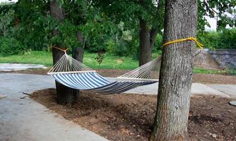 Hammock made of natural fabric, suspended from ropes in the garden on trees photo