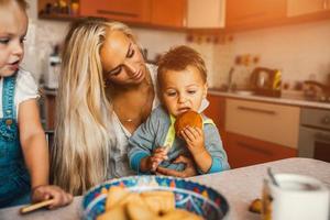 Mother with kids on kitchen photo