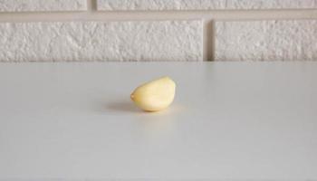 Garlic clove isolated on a white kitchen table background photo