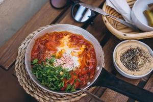 Shakshuka, Fried Eggs in Tomato Sauce on the Table photo