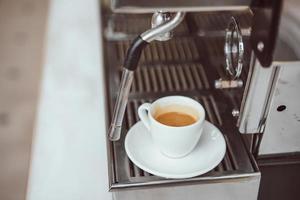 close-up view of glass cup with cappuccino and coffee machine photo