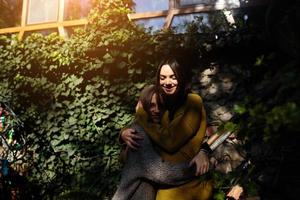 Two girls hugging in the shade of of leaves photo