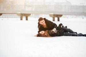 Girl and guy lie on snow photo