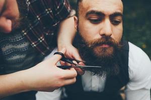 barber shaves a bearded man photo