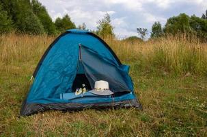 A tourist tent stands in a clearing. Concepts of travel and adventure. Background of nature. photo