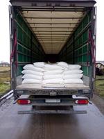 The concept of logistics conveyor delivery. Modern large trailer, with bags of flour. Route of Industrial Warehouses photo