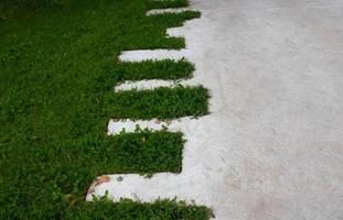 Green lawn and concrete zigzag path in the park photo