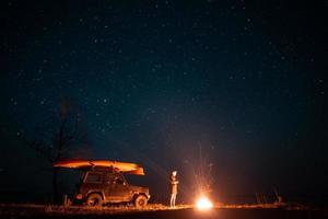 Happy man standing in front burning bonfire photo