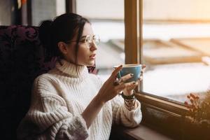 Girl enjoying flavor of coffee while relaxing at coffee shop photo