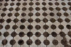 Geometric gray concrete tile with eco-parking cells With a hole for grass. Top view, paving stones for grass, block tiles made of concrete in the form of connected circles photo