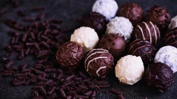 sixteen chocolate truffles beside some chocolate flakes photo